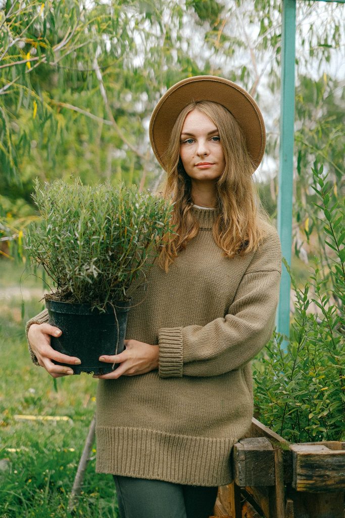 A lady carrying a plant, planting is an activity that supports rewilding